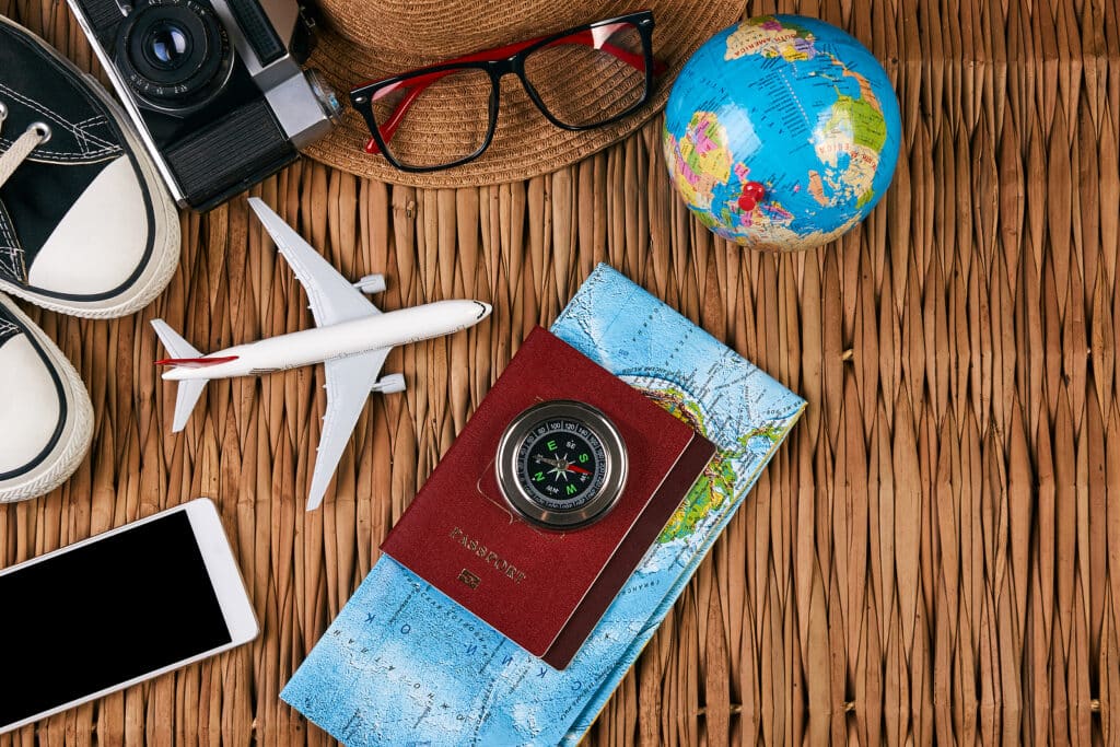 Passport travel document photo camera sunglasses globe map, top view. Summer vacation, travel, tourism and objects concept. Traveler items vacation travel accessories holiday long weekend day concept.